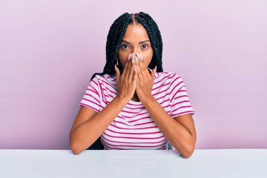 Masada oturan İspanyol elbiseli güzel kadın yanlışlıkla ağızlarını kapatarak şok geçirdi. gizli kavram. 