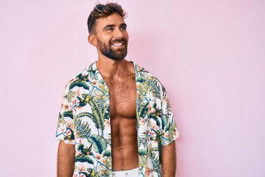 Gündelik yaz kıyafetleri giyen genç İspanyol adam elleri kafasında, şaşırmış ve kızgın yüzüyle stresli ve hayal kırıklığına uğramış. 