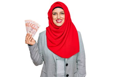 İslami tesettür giyen güzel İspanyol kadın elinde Singapur Doları banknotları tutuyordu. Pozitif ve mutlu görünüyordu. Kendine güvenen bir gülümsemeyle duruyordu. 