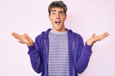 Gayri resmi mor kazak giyen genç yakışıklı adam zaferi mutlu bir gülümsemeyle ve kazanan yüz ifadesiyle kutluyor. 