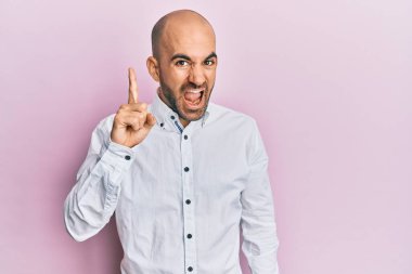 Gündelik kıyafetler giyen genç İspanyol adam başarılı bir fikirle işaret ediyor. Heyecanlı ve mutlu. Bir numara.. 