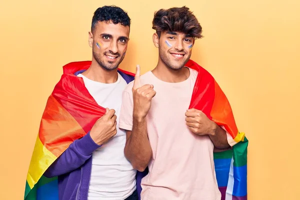 Joven Gay Pareja Vistiendo Arco Iris Lgbtq Bandera Sonriendo Con — Foto de Stock