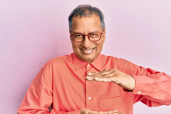印度中年男子 身穿休闲装 戴着眼镜 手拿着大号和大号的手势 测量符号 微笑着看着摄像机 计量概念 — 图库照片