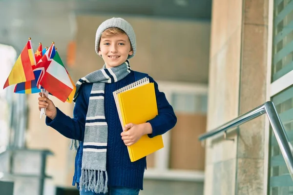 Adorável Garoto Estudante Loiro Sorrindo Feliz Segurando Bandeiras Diferentes Países — Fotografia de Stock