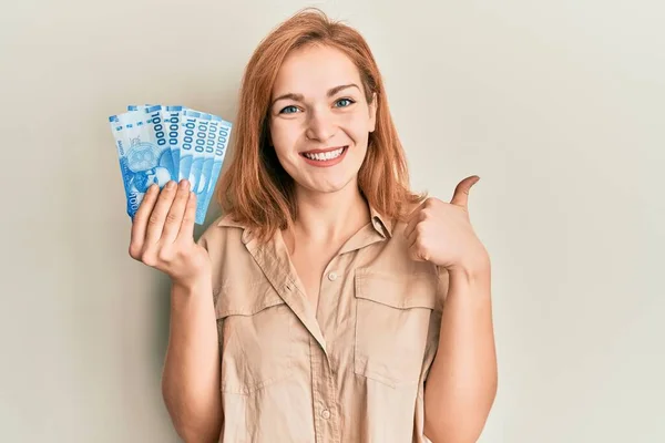 Молодая Белая Женщина Держит 10000 Чилийских Песо Улыбаясь Счастливой Позитивной — стоковое фото