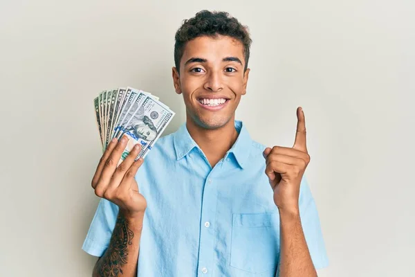 Joven Hombre Afroamericano Guapo Sosteniendo Dólares Sonriendo Con Una Idea —  Fotos de Stock