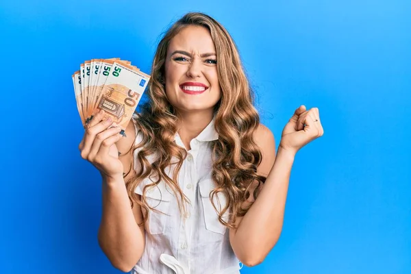 Menina Loira Jovem Segurando Notas Euro Gritando Orgulhoso Celebrando Vitória — Fotografia de Stock