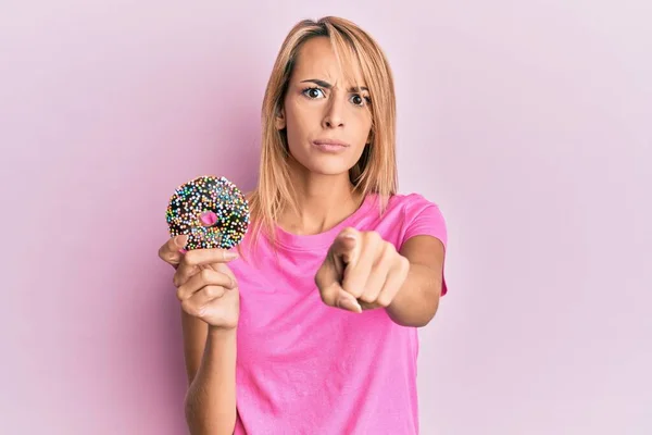 Hermosa Mujer Rubia Sosteniendo Donut Señalando Con Dedo Cámara Usted — Foto de Stock