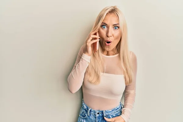 Молодая Блондинка Разговаривающая Смартфону Испуганная Удивленная Открытым Ртом Удивления Лица — стоковое фото
