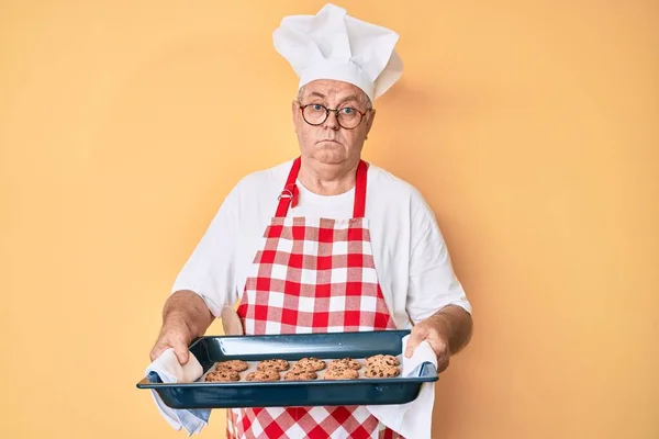 Älterer Grauhaariger Mann Bäckeruniform Der Hausgemachte Kekse Der Hand Hält — Stockfoto