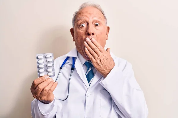 Starszy Siwowłosy Lekarz Noszący Stetoskop Trzymający Tabletki Białym Tle Zakrywający — Zdjęcie stockowe