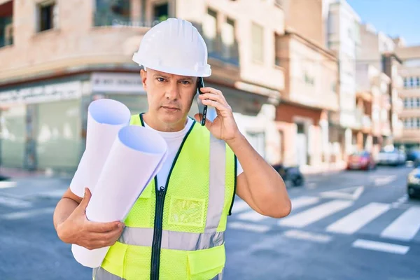 Architekt Mittleren Alters Spricht Auf Dem Smartphone Und Hält Baupläne — Stockfoto