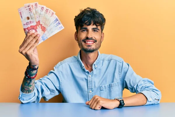 Junger Hispanischer Mann Mit Kolumbianischen Pesos Auf Dem Tisch Sitzend — Stockfoto