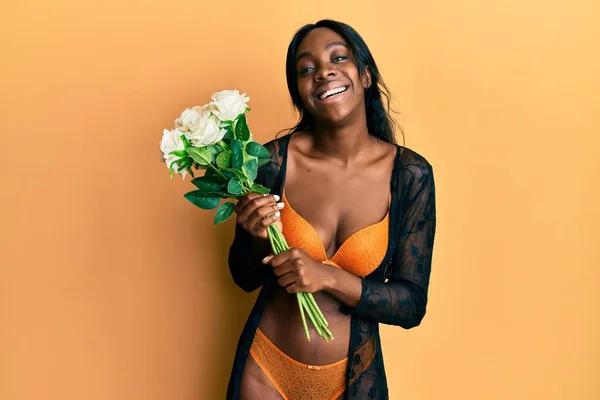 Νεαρή Αφροαμερικανή Γυναίκα Που Φοράει Εσώρουχα Κρατώντας Λουλούδια Που Φαίνονται — Φωτογραφία Αρχείου