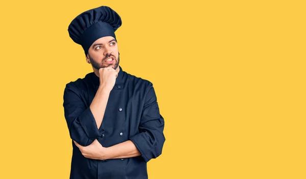 Joven Hombre Hispano Con Uniforme Cocina Con Mano Barbilla Pensando — Foto de Stock