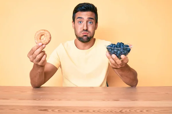 Νεαρός Ισπανός Τρώει Πρωινό Κρατώντας Ντόνατ Και Βατόμουρα Φουσκώνοντας Μάγουλα — Φωτογραφία Αρχείου
