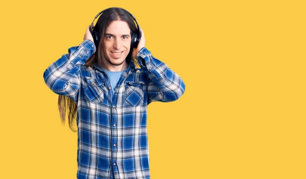 Young Adult Man Long Hair Listening Music Using Headphones Looking — Stock Photo, Image