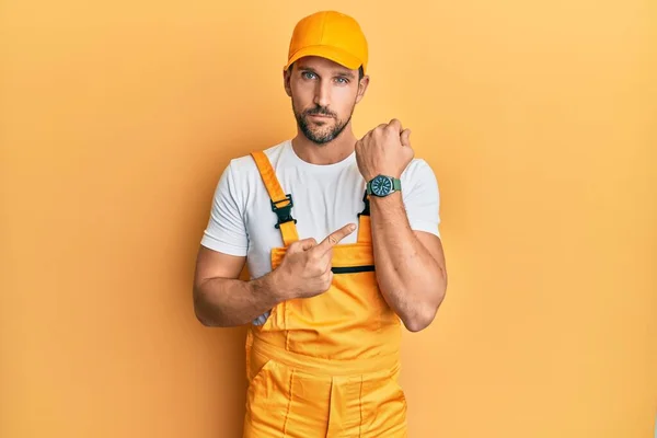 Young Handsome Man Wearing Handyman Uniform Yellow Background Hurry Pointing — Stockfoto