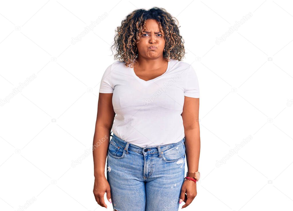 Young african american plus size woman wearing casual clothes puffing cheeks with funny face. mouth inflated with air, crazy expression. 