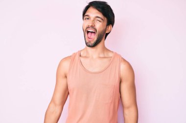 Yakışıklı, sıradan kıyafetler giyen, kameraya seksi bir ifadeyle bakan, neşeli ve mutlu yüzlü bir İspanyol.. 