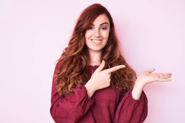 Kış süveteri giyen genç ve güzel bir kadın kameraya hayret ediyor ve gülümsüyor.. 