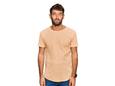 Sakallı yakışıklı genç adam rahat bir tişört giyiyor uykulu ve yorgun görünüyor, yorgunluktan yorgun ve akşamdan kalma, sabahları tembel gözler.. 