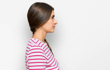 Latin kökenli genç bir kadın rahat bir görünüm ve kendine güvenen bir gülümseme takınıyor.. 