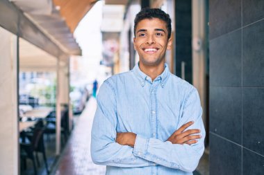 Genç Latin adam gülümseyerek şehirde mutlu mesut yürüyor..