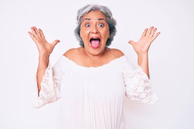 Son sınıf Latin kökenli gri saçlı kadın çılgın kutlamalar yapıyor ve kolları açık ve gözleri açık heyecanla haykırarak başarıyı kutluyor. Kazanan konsept 