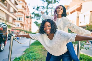 Güzel Afro-Amerikan annesi kızı kucağına alıp parkta gezdiriyor..