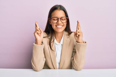 Ofiste çalışan güzel İspanyol kadın umut ve gözlerin kapalı gülümseyerek bana işaret ediyor. Şans ve batıl inançlar. 