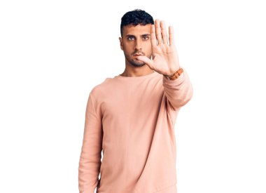 Günlük kıyafetler giyen genç İspanyol adam avucunun içi gibi şarkı söylemeyi kesiyor. Yüzünde olumsuz ve ciddi bir jest olan uyarı ifadesi. 