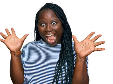 Saçları örgülü genç siyah bir kadın çılgın kutlamalar yapıyor ve başarıya hayret ediyor. Kolları açık, gözleri açık, heyecanlı çığlıklar atıyorlar. Kazanan konsept 