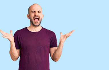 Gündelik tişört giyen genç yakışıklı adam başarı için deli ve çılgınlığı kutluyor kollarını kaldırmış ve gözlerini kapatmış heyecanla bağırıyor. Kazanan konsept 