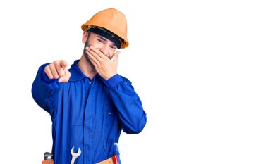 İspanyol üniformalı genç adam sana gülüyor, eli ağzında kamerayı işaret ediyor, yüz ifadesi utanç verici. 