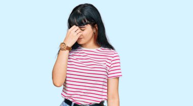 Günlük kıyafetler giyen genç İspanyol kız yorgun burnu ve gözleri ovuşturup yorgun ve baş ağrısı çekiyor. Stres ve hüsran kavramı. 