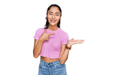 Diş teli takan İspanyol genç kız kameraya hayret ediyor ve gülümsüyor.. 