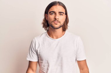 Yüzünde ciddi bir ifade olan sıradan kıyafetler giyen genç yakışıklı bir adam. Basit ve doğal bir şekilde kameraya bakıyorsun.. 