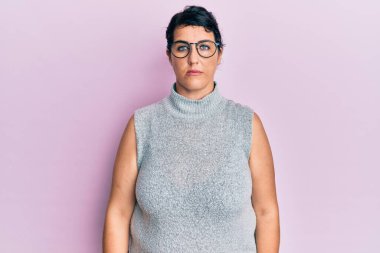 Artı esmer, sıradan kıyafetler giyen ve yüzünde ciddi bir ifade olan gözlüklü bir kadın. Basit ve doğal bir şekilde kameraya bakıyorsun.. 