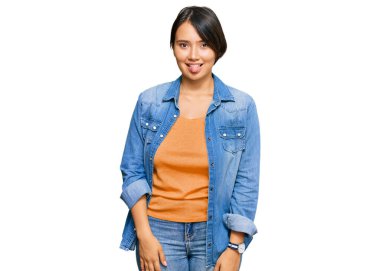 Kısa saçlı, sıradan bir kot ceket giyen, dilini komik bir ifadeyle dışarı çıkaran genç, güzel İspanyol bir kadın. duygu kavramı. 