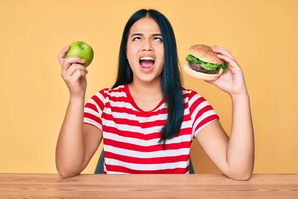 Ung Asiatisk Flicka Jämföra Hamburgare Och Friska Äpple Arg Och — Stockfoto