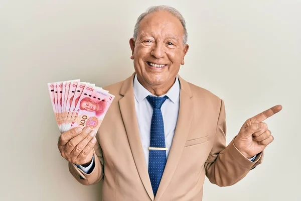 Hombre Caucásico Mayor Sosteniendo Billetes Chinos Yuan Sonriendo Feliz Señalando —  Fotos de Stock