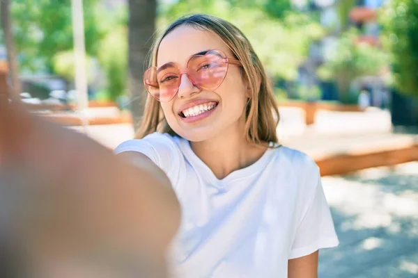 금발의 여성이 모양의 선글라스를 사진을 찍으며 야외에서 행복하게 — 스톡 사진