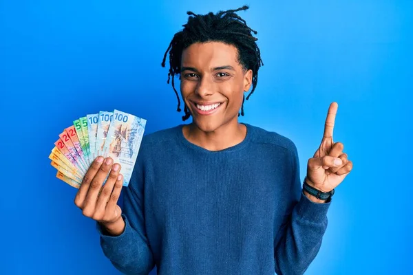 Νεαρός Αφροαμερικάνος Που Κρατάει Ελβετικά Χαρτονομίσματα Μια Ιδέα Ερώτηση Δείχνοντας — Φωτογραφία Αρχείου