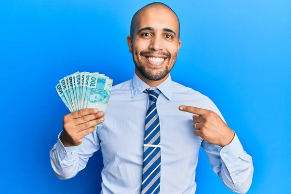 Hispanic Adult Man Holding 100 Brazilian Real Banknotes Smiling Happy — Stock Photo, Image