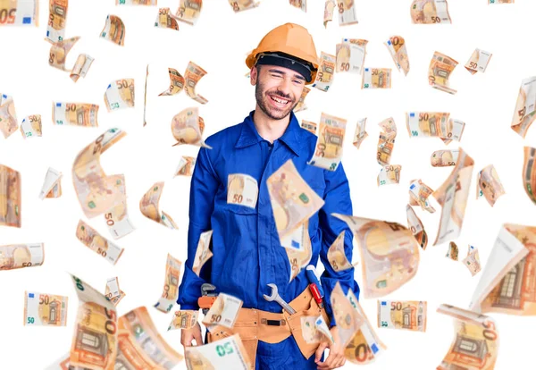 İspanyol üniformalı genç adam kameraya seksi bir ifadeyle bakıyor, neşeli ve mutlu bir yüzle..