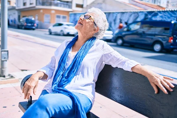 Starsza Seniorka Siwymi Włosami Uśmiechnięta Świeżym Powietrzu Siedząca Ławce — Zdjęcie stockowe