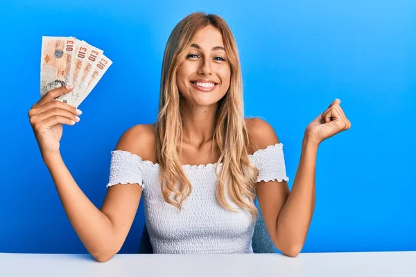 Beautiful Blonde Young Woman Holding United Kingdom Pounds Banknotes Screaming — Stockfoto