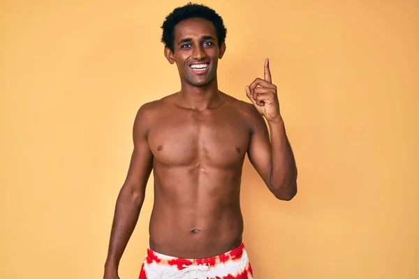 Een Afrikaanse Knappe Man Een Zwempak Die Met Zijn Vinger — Stockfoto