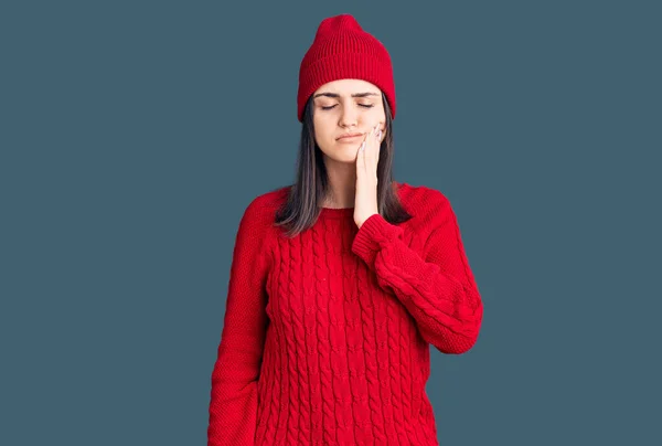 스웨터 모자를 아름다운 소녀는 치통이나 병때문에 손으로 만지작거리며 스러운 표정을 — 스톡 사진